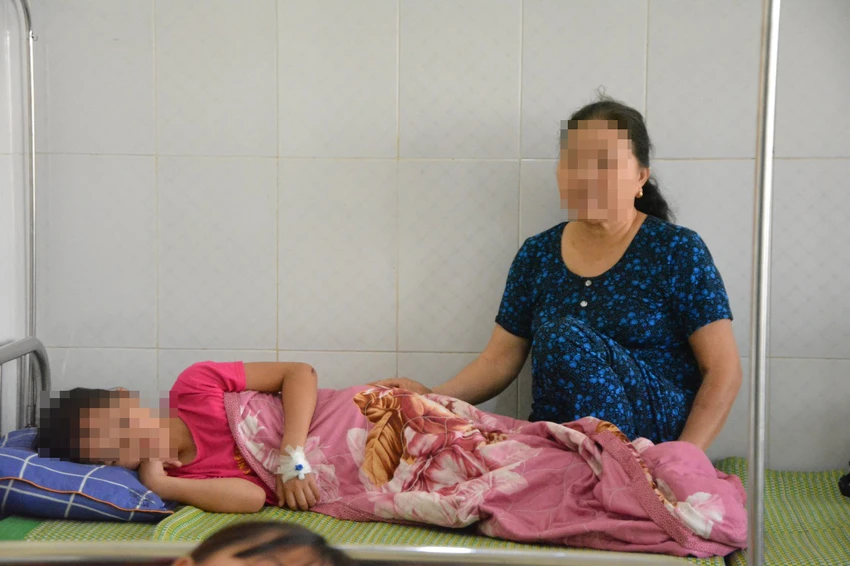 Người nhà đang chăm sóc một em học sinh. Ảnh: AX Người nhà đang chăm sóc một em học sinh. Ảnh: AX