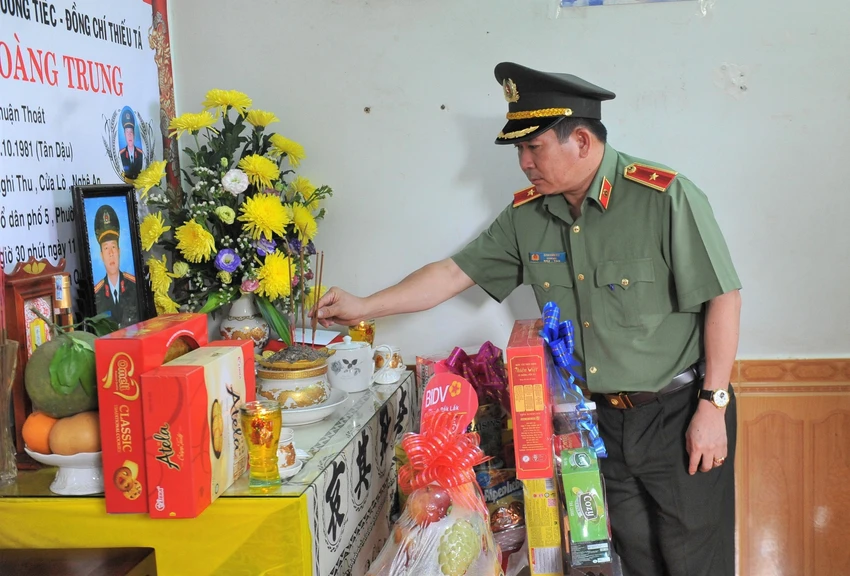 Thiếu tướng Đinh Văn Nơi thắp hương tại gia đình Thiếu tá Hoàng Trung. Ảnh: NG