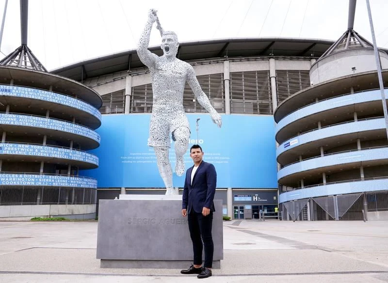 Aguero...đứng dưới "bức tượng Toni Kroos" chăng? Ảnh: Getty ...Thật chẳng giống cựu tiền đạo Man "xanh" tí nào cả mà rất giống Kroos với sống mũi thẳng. Quả là Toni Kroos nên "mua" bức tượng này về vì nó rất giống anh. Ảnh: Getty Khuôn mặt của Toni Kroos và bức tượng Aguero là một. Ảnh: Getty Đôi chân thật của Aguero...cũng cơ bắp "hình bắp chuối" hơn chứ không phải thế này. Ảnh: Getty Hẳn là Aguero mà rất giống Toni Kroos ăn mừng bàn thắng. Ảnh: Getty Bức tượng Aguero kỷ niệm 10 năm ngày vô địch Premier League của Man. "xanh" sau tượng đài Vincent Kompany, David Silva. Aguero có mặt và ký tặng fan. Ảnh: Getty