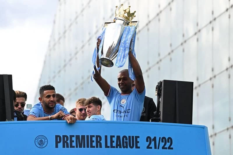 Fernando nâng cao chiếc cúp vàng. Robben Dias ăn mừng danh hiệu. ...Nhưng bao giờ thành cổ Manchester mới chứng kiến ngôi vô địch Champions League của Man. xanh? Nếu phía dưới chữ Champions...là Champions League thì hoành tráng hơn. Những cầu thủ Man. Xanh thật...điệu đà.