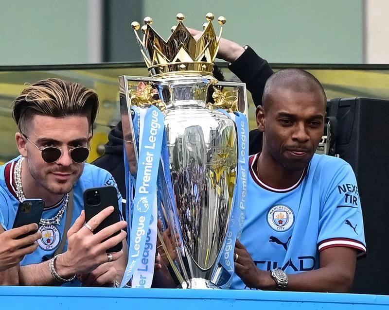 Grealish và Fernando cùng chiếc cúp vô địch. Fernando nâng cao chiếc cúp vàng. Robben Dias ăn mừng danh hiệu. ...Nhưng bao giờ thành cổ Manchester mới chứng kiến ngôi vô địch Champions League của Man. xanh? Nếu phía dưới chữ Champions...là Champions League thì hoành tráng hơn. Những cầu thủ Man. Xanh thật...điệu đà.