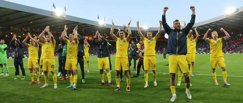 Trận Play off World Cup 2022 giữa Ukraine và Scotland lẽ ra diễn ra hồi tháng 3 qua, nhưng cho chiến tranh nên FIFA hoãn lại đến tháng sáu. Ngay tại Glasgow, Ukraine (vàng) đánh bại chủ nhà Scotland 3-1. Với chiến thắng này, Ukraine sẽ đá chung kết với Wales vào chủ nhật tới tại Hamdem Park. Thật kỳ lạ là sân Glasgow nhuộm vàng-xanh (màu quốc kỳ Ukraine) hầu như bốn bề. Hàng ngàn fan Scotland cũng ủng hộ đội bóng Đông Âu để vượt qua giai đoạn khó khăn của chiến tranh nơi quê nhà. Thủ môn Callum McGregor ghi bàn danh dự cho Scotland. Scotland buồn vì giấc mơ World Cup qua đi, nhưng họ không oán trách fan nhà ủng hộ Ukraine. Tiền đạo Yarmolenko ăn mừng bàn thắng. Yaremchuk (9) cũng có bàn thắng trong chiến thắng 3-1. 25 năm kể từ France 98 đến nay, Scotland vẫn chưa thể góp mặt tại World Cup trở lại. Ukraine sẽ đá chung kết Play off với Xứ Wales vào chủ nhật này để tranh vé đi Qatar cuối năm nay. Tuyển Ukraine đa phần cầu thủ đá giải trong nước mà năm 2022 này bóng đá Ukraine bị đứng hình vì chiến tranh.