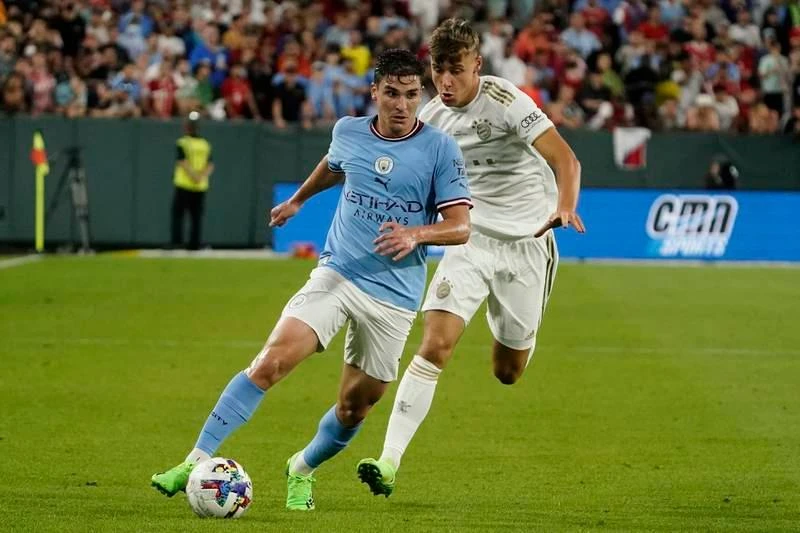 Julian Alvarez đi bóng qua Paul Wanner. Haaland chào khán giả trên sân Lambeau. Mùa hè này hàng loạt ông lớn châu Âu đến Mỹ để đá giao hữu với nhau. Grealish "không chiến" với hậu vệ Nianzou của Bayern. Các sân bóng Mỹ mùa hè này chào đón những Bayern, Man. City, Barcelona, Real Madrid... Haaland ghi bàn duy nhất trận giúp Man. City thắng "Hùm xám" 1-0. Nếu còn khoác áo Borussia Dortmund, Haaland và đồng đội dễ gì đánh bại "Hùm xám" Bayern.