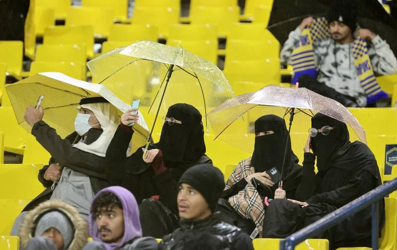 Lẽ ra vòng 12 giải Saudi Arabia diễn ra giữa tuần này, song do thời tiết mưa quá kinh khủng, hệ thống điện của sân lại gặp vấn đề nên trận đấu dời lại vào thứ sáu, đó là vòng đấu Al Nassr tiếp Al Taj Fan đến xem Ronaldo, tuy nhiên siêu sao của đội chưa thể ra sân được do án phạt treo giò 2 trận ở Anh cũng có hiệu lực tại giải Saudi Arabia. Tuy nhiên Al Nassr cũng thắng 2-0 và có 29 điểm dẫn đầu bảng xếp hạng sau 12 vòng. Ronaldo ngồi trên khu VIP của sân với các lãnh đạo Al Nassr. Một fan nữ tiến đến xin chụp hình chung với Ronaldo. ...OK, chụp nhé. Cho đến nay, áo chính hãng của Ronaldo đã bán được 50 ngàn chiếc. Ronaldo quan sát sân Mrsool qua cửa kính. Ronaldo chào fan khi hiện diện trên khu VIP.