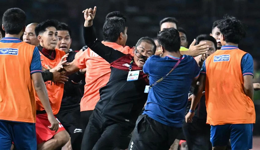 Trưởng đoàn Sumardji (mang kính) đã có pha ăn mừng khiêu khích khiến các trợ lý Thái Lan cay và lao ra ăn thua đủ. Lực lượng cảnh sát làm nhiệm vụ vào sân kịp thời. Ảnh: ANH PHƯƠNG Trưởng đoàn Sumardji đã té ngã, nhưng các cầu thủ Thái Lan vẫn lao vào đạp và tấn công. Ảnh: ANH PHƯƠNG Cầu thủ Koman Teguh (số 4, Indonesia, đỏ) và thủ môn Yoponwit (vàng) của Thái Lan bị trọng tài Kasim rút thẻ đỏ trong tình huống bạo lực này. Trưởng đoàn Sumardji bị tấn công không thương tiếc là vì ăn mừng quá khiêu khích phía Thái Lan.
