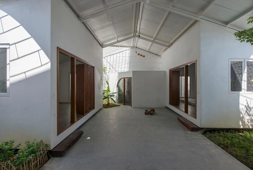 Bằng việc sử dụng màu trắng và ghi bao trùm các không gian, ngôi nhà như được mở rộng khi kết hợp với cây xanh.