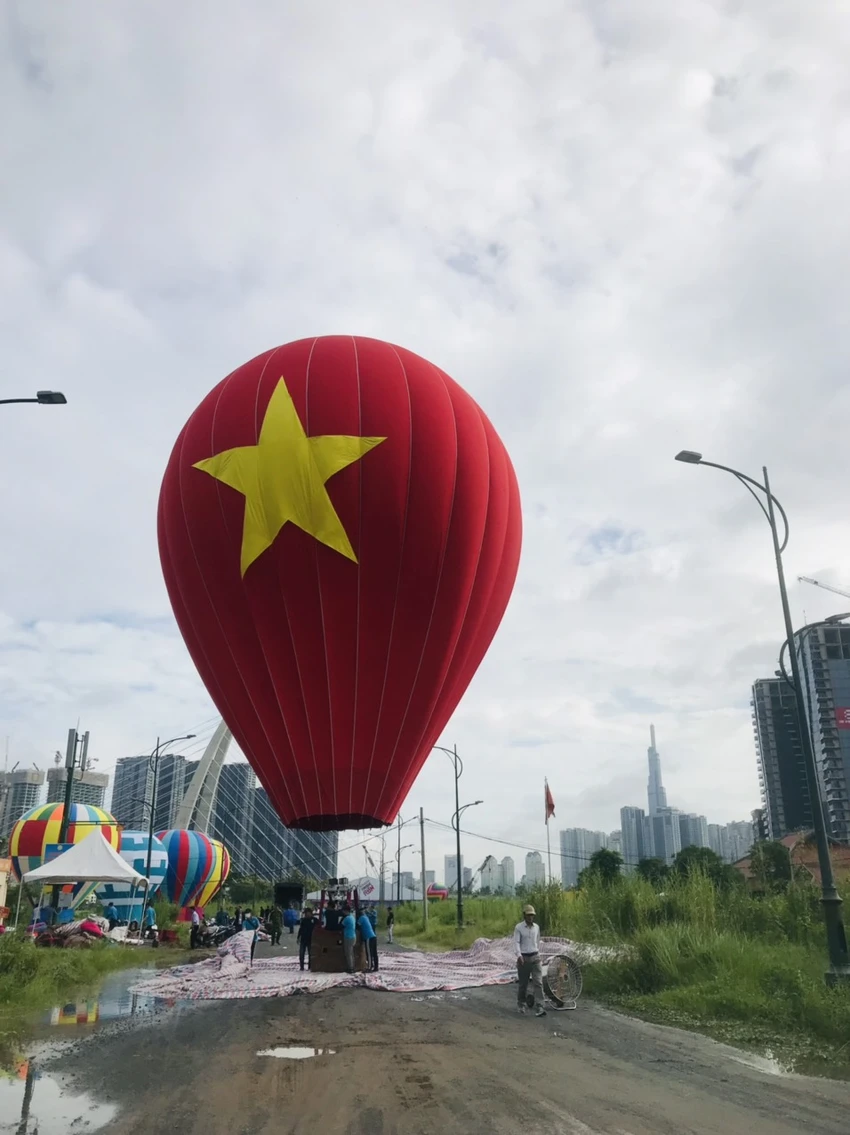 Năm nay khinh khí cầu sẽ không kéo Quốc kỳ như năm ngoái mà thay vào đó một khinh khí cầu in hình Quốc kỳ cao 18m với đường kính 14m. Năm nay khinh khí cầu sẽ không kéo Quốc kỳ như năm ngoái mà thay vào đó một khinh khí cầu in hình Quốc kỳ cao 18m với đường kính 14m.