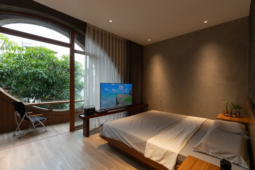 Phòng ngủ tầng ba với khung cửa kính lớn, gợi nhớ trải nghiệm thức dậy giữa thiên nhiên trong những chuyến đi xa. ngoi-nha-20.jpg