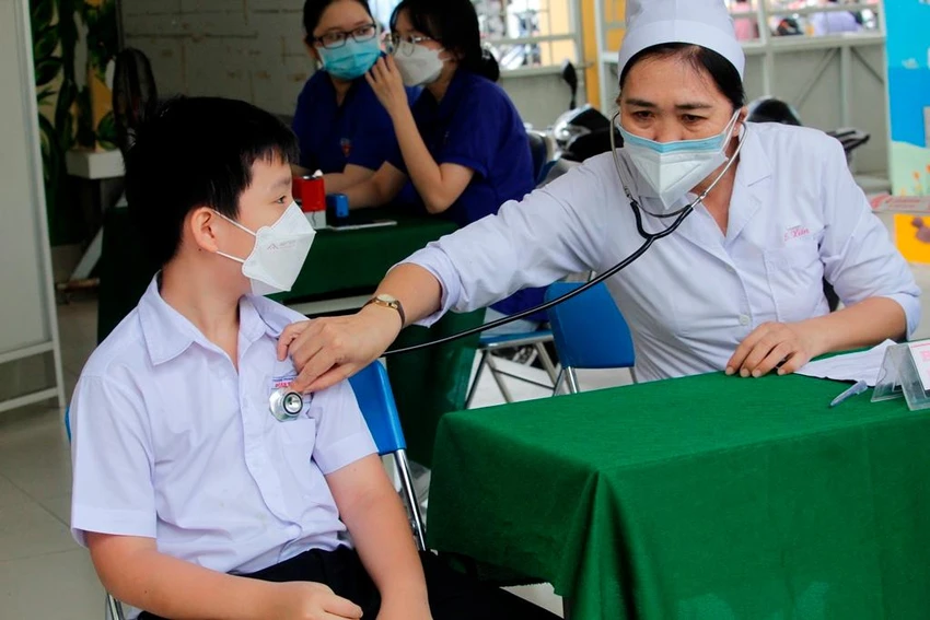 Bác sĩ tư vấn nghe tim, phổi trước khi cho các bé vào khu vực tiêm. Ảnh: NHẪN NAM Bác sĩ tư vấn nghe tim, phổi trước khi cho các bé vào khu vực tiêm. Ảnh: NHẪN NAM