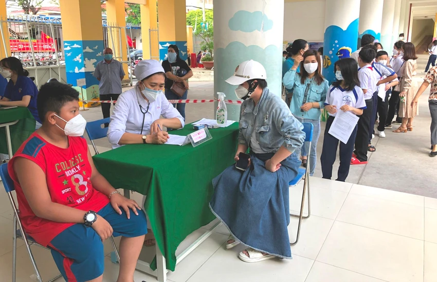 Phụ huynh được cùng con nghe bác sĩ khám sàng lọc tư vấn trước khi vào tiêm. Ảnh: NHẪN NAM Phụ huynh được cùng con nghe bác sĩ khám sàng lọc tư vấn trước khi vào tiêm. Ảnh: NHẪN NAM