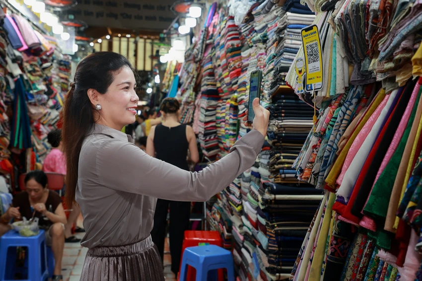 Người dân thanh toán mua hàng bằng mã QR code. Người dân thanh toán mua hàng bằng mã QR code.