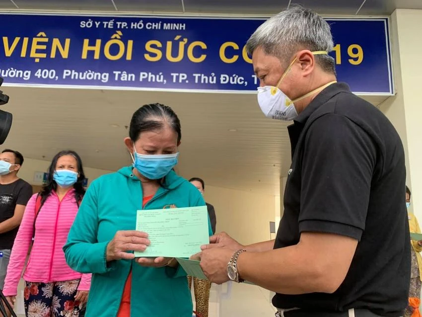 Thứ trưởng Bộ Y tế Nguyễn Trường Sơn có mặt trao giấy chứng nhận xuất viện cho bệnh nhân ở Bệnh viện hồi sức COVID-19. Ảnh: HOÀNG LAN