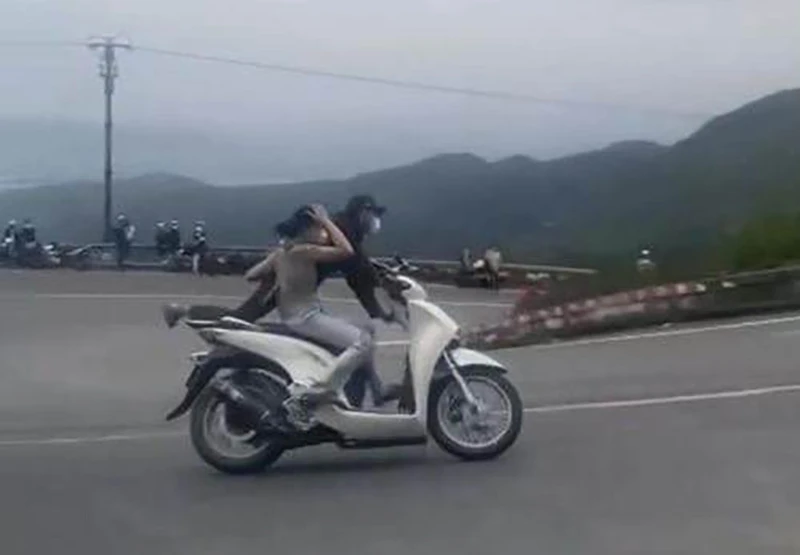 Hình ảnh cặp vợ chồng "diễn xiếc" trên đèo Hải Vân. Ảnh cắt từ clip Hình ảnh cặp vợ chồng "diễn xiếc" trên đèo Hải Vân. Ảnh cắt từ clip