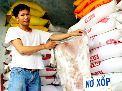 Anh Mai Văn Hiệu bên chiếc áo thấm đẫm máu hôm bị bọn cướp bắn. Ảnh:Hoàng Trường chu-tiem-gao-4578-1407836721.jpg