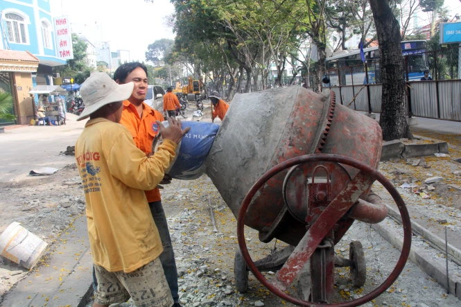Công nhân đang đổ bê tông nền hạ trên vỉa hè đường Trần Quốc Hoàn sáng 19-1 - Ảnh: Quang Khải Công nhân đang đổ bê tông nền hạ trên vỉa hè đường Trần Quốc Hoàn sáng 19-1 - Ảnh: Quang Khải