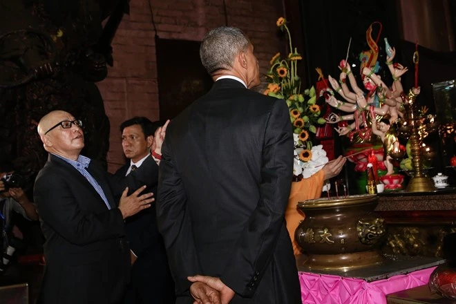 Giáo sư Dương Ngọc Dũng giải thích cho Tổng thống Obama về ý nghĩa của việc thắp ba cây nhang. Ảnh:Hải An. Nguoi huong dan ong Obama o chua Ngoc Hoang ke gi? hinh anh 1