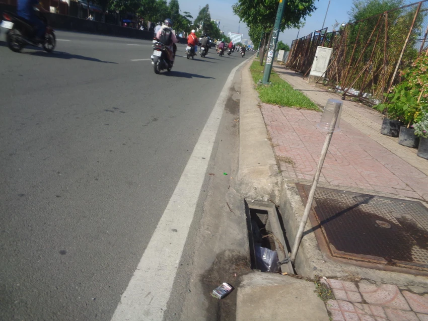 Mất nắp chắn rác, người dân gần đó dựng tạm cây để cảnh báo người đi đường không lọt chân hoặc bánh xe xuống đây Mất nắp chắn rác, người dân gần đó dựng tạm cây để cảnh báo người đi đường không lọt chân hoặc bánh xe xuống đây