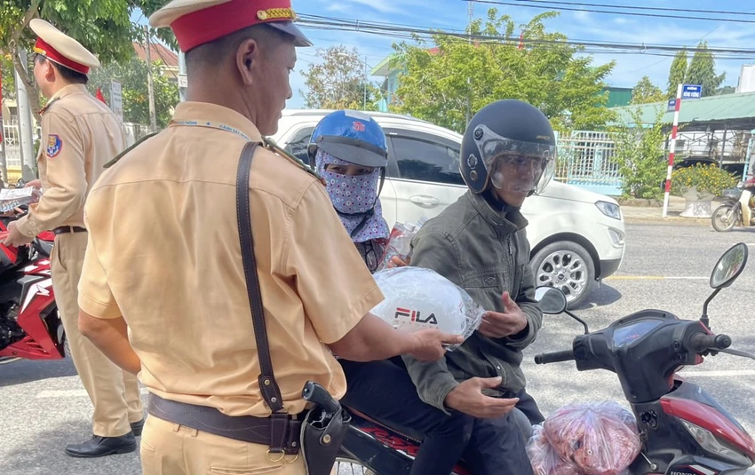 CSGT đổi mũ bảo hiểm mới cho người dân. Ảnh: VÕ TÙNG