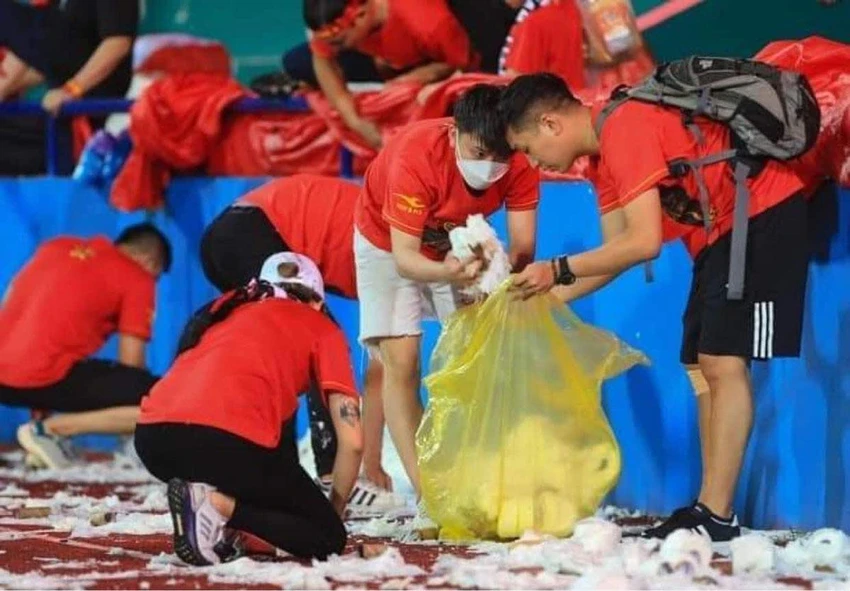 Các CĐV nán lại dọn dẹp chiến trường nhưng không thấm vào đâu so với hai cơn mưa giấy trước và mưa trời tiếp theo sau đó. Ảnh: HY Các CĐV nán lại dọn dẹp chiến trường nhưng không thấm vào đâu so với hai cơn mưa giấy trước và mưa trời tiếp theo sau đó. Ảnh: HY