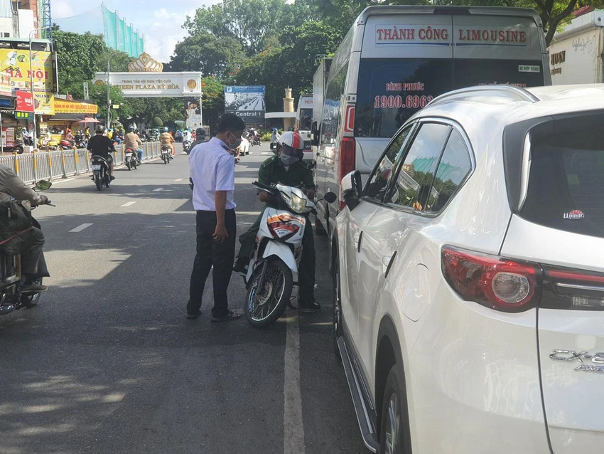 Nhân viên đang thu phí đỗ ô tô dưới lòng đường Lê Hồng Phong, quận 10, TP.HCM. Ảnh: KC