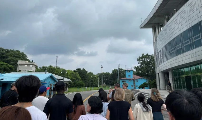 Binh nhì Travis T. King mặc áo đen, đội mũ đen cùng đoàn tham quan khu vực an ninh chung ở Bàn Môn Điếm hôm 18-7. Ảnh: REUTERS Binh nhì Travis T. King mặc áo đen, đội mũ đen cùng đoàn tham quan khu vực an ninh chung ở Bàn Môn Điếm hôm 18-7. Ảnh: REUTERS