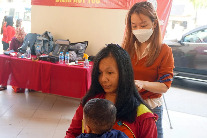 Chị Đinh Thị Cúc được cắt tóc miễn phí. Ảnh: NGUYỄN QUYÊN Chị Đinh Thị Cúc được cắt tóc miễn phí. Ảnh: NGUYỄN QUYÊN
