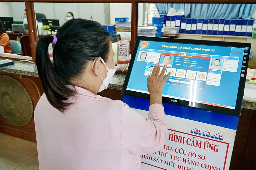 Người dân thực hiện đánh giá cán bộ trên kiốt sau khi làm xong thủ tục hành chính tại UBND phường Bình Hưng Hòa A, quận Bình Tân, TP.HCM. Ảnh: BẢO PHƯƠNG nguoi-dan-tphcm-cham-diem-can-bo