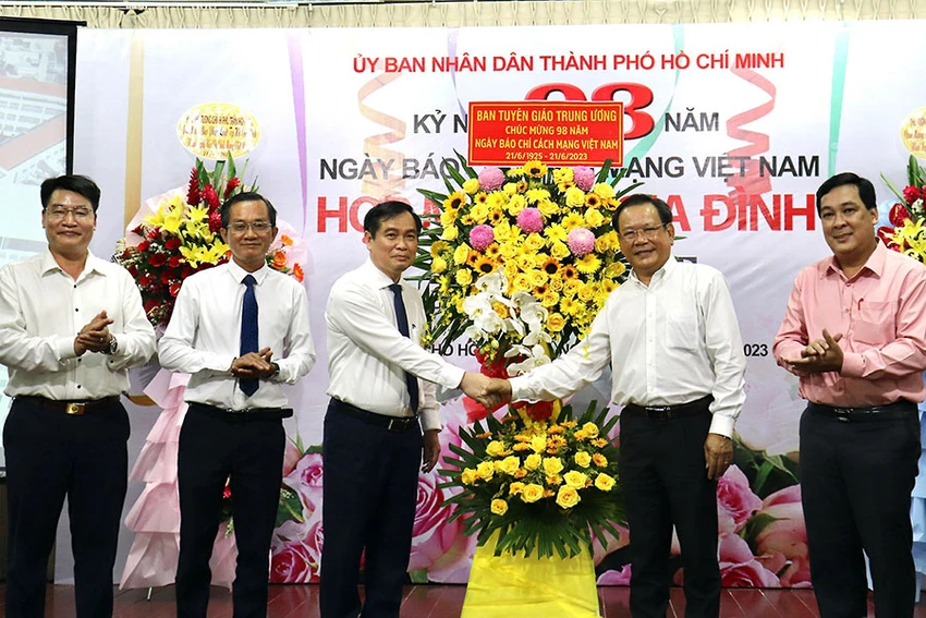 Phó Trưởng ban Tuyên giáo Trung ương Phan Xuân Thủy (giữa) tặng hoa chúc mừng báo Pháp Luật TP.HCM nhân ngày 21-6. Ảnh: NHẬT DIỄM