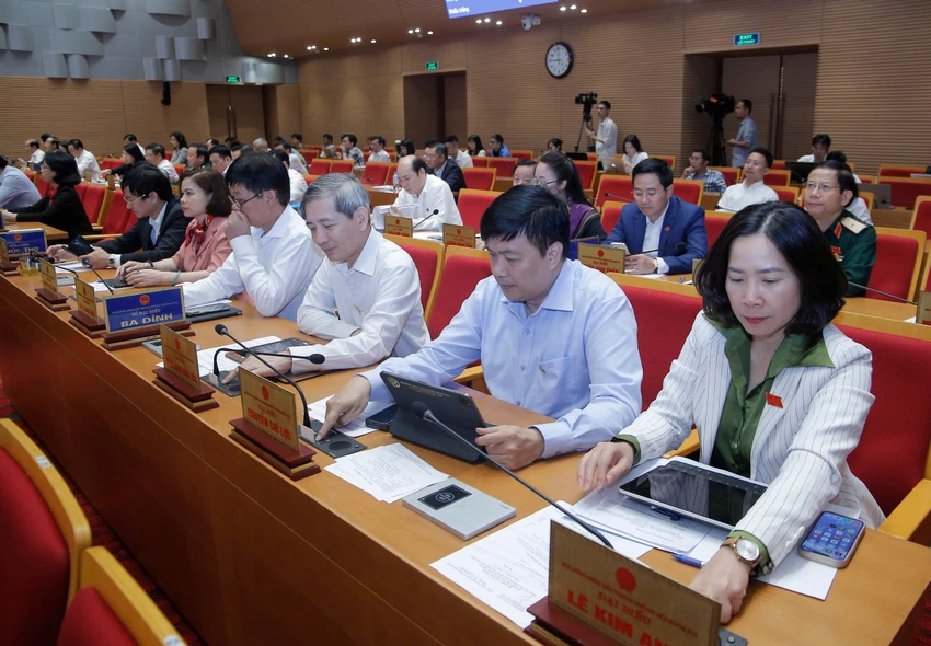 Các đại biểu HĐND TP Hà Nội bấm nút thông qua dự thảo Nghị quyết quy định việc áp dụng biện pháp yêu cầu ngừng cung cấp dịch vụ điện, nước đối với các công trình vi phạm về đất đai, trật tự xây dựng, phòng cháy chữa cháy trên địa bàn thành phố Hà Nội. Ảnh: TP