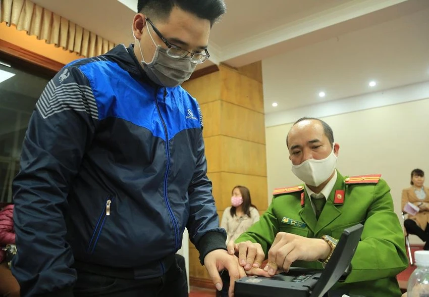Công an làm thủ tục cấp CCCD gắn chip cho người dân. Ảnh: UYÊN TRANG
