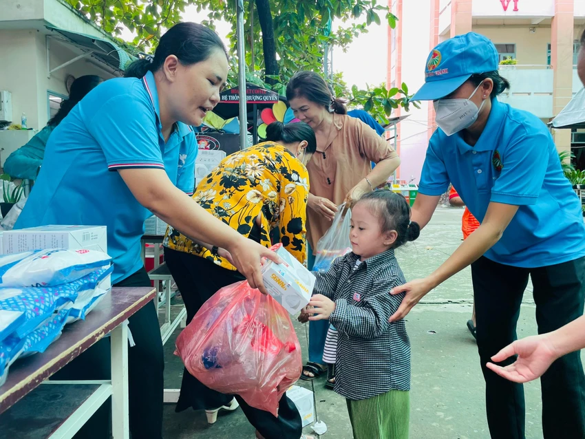 Người dân mang rác thải nhựa đến và được nhận quà là khẩu trang y tế, túi rác dễ phân hủy. Ảnh: VIỆT HOA Người dân mang rác thải nhựa đến và được nhận quà là khẩu trang y tế, túi rác dễ phân hủy. Ảnh: VIỆT HOA