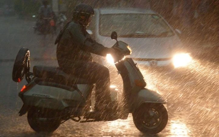 Người dân Ấn Độ đi lại trong mưa bão ở thành phố Amritsar.