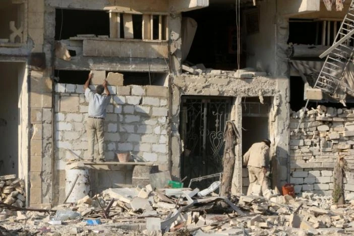 Nga sắp liên quân với Mỹ ở chiến trường Syria ảnh 1 Một người đàn ông đang xây lại tường nhà của một tòa nhà bị hư hỏng ở khu vực al-Katerji ở Aleppo, Syria ngày 13-8-2016. Ảnh: Reuters