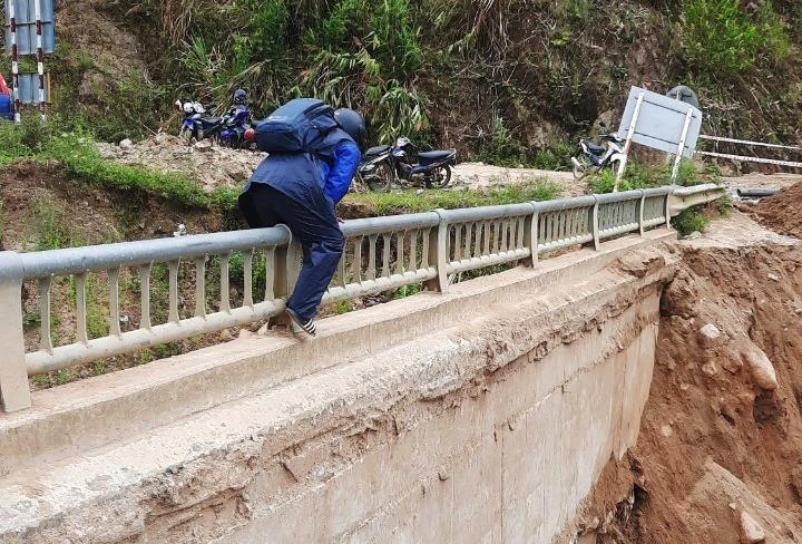 Người dân trèo lên thành cầu đi bộ ra ngoài. Ảnh: CTV
