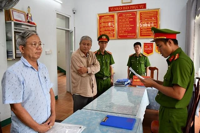 Cảnh sát tống đạt các quyết định đối với Hoàng (trái) và Tấn (phải). Ảnh: CA Cảnh sát tống đạt các quyết định đối với Hoàng (trái) và Tấn (phải). Ảnh: CA