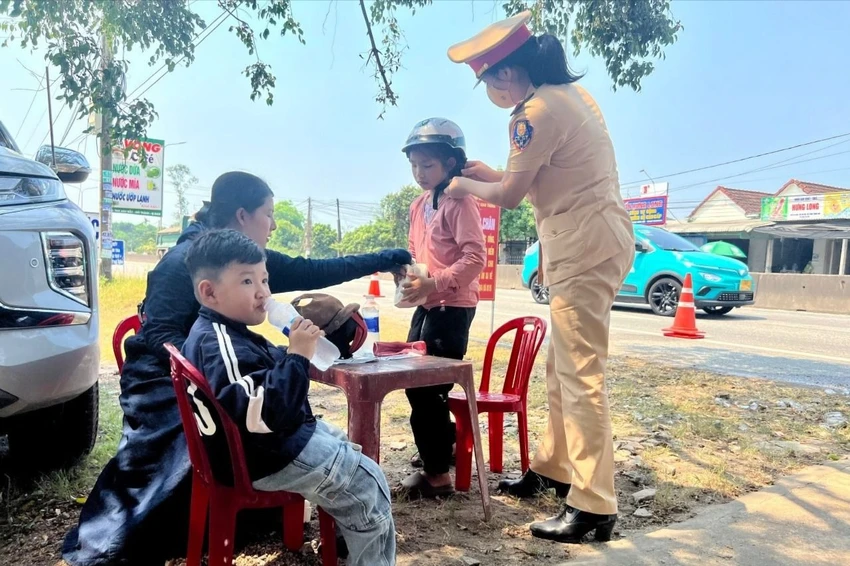 CSGT Quảng Nam phát nước, khăn lạnh và đổi mũ bảo hiểm cho người dân đi xe máy về quê nghỉ lễ. Ảnh: TN