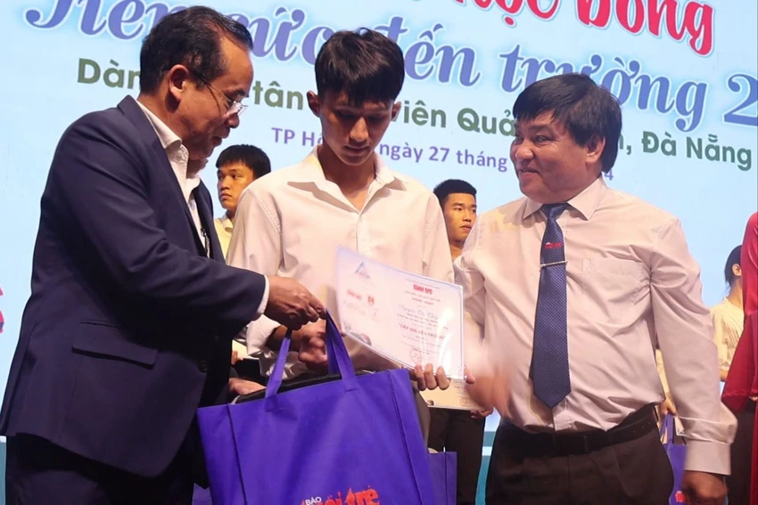 Ông Trần Anh Tuấn, Phó Chủ tịch UBND tỉnh Quảng Nam (trái) và ông Lê Thế Chữ, Tổng biên tập Báo Tuổi trẻ (phải) trao học bổng tiếp sức đến trường cho tân sinh viên. Ảnh: AT