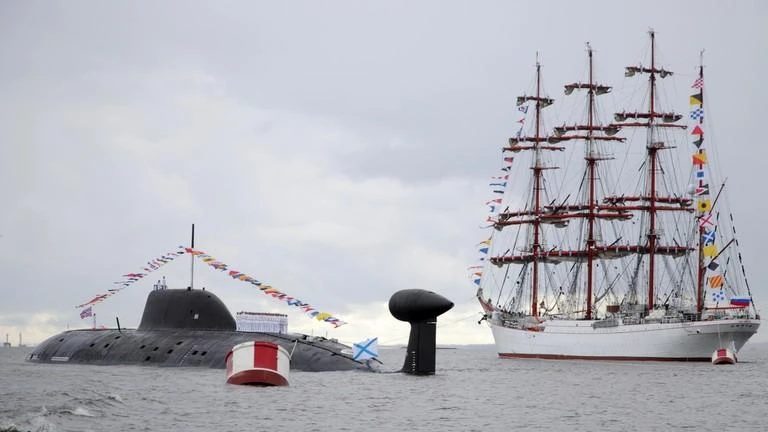 Tàu ngầm tàng hình chạy bằng năng lượng hạt nhân Severodvinsk (trái) và thuyền Sedov 4 cột buồm (phải) tại buổi diễu binh trên sông Neva, TP St.Petersburg, Nga, ngày 31-7. Ảnh: SPUTNIK