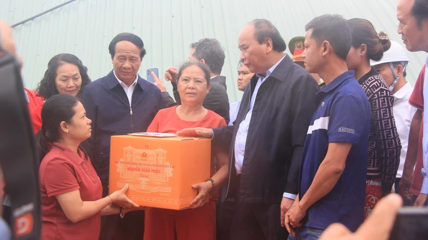Chủ tịch nước trao quà cho hộ dân bị thiệt hại nặng do mưa lũ vừa qua. Ảnh: NGÔ QUANG