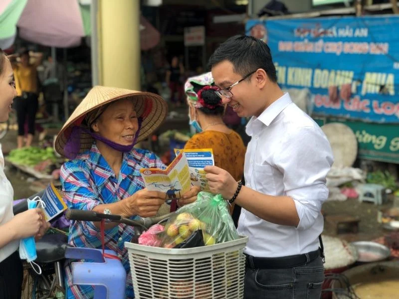 Nhân viên BHXH tuyên truyền chính sách để thu hút người dân tham gia BHXH tự nguyện. Ảnh: N.LONG