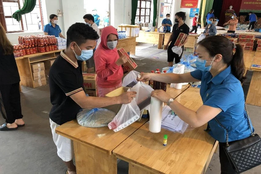 Người lao động nhận quà hỗ trợ trong đợt cao điểm dịch COVID-19. Ảnh: V.LONG