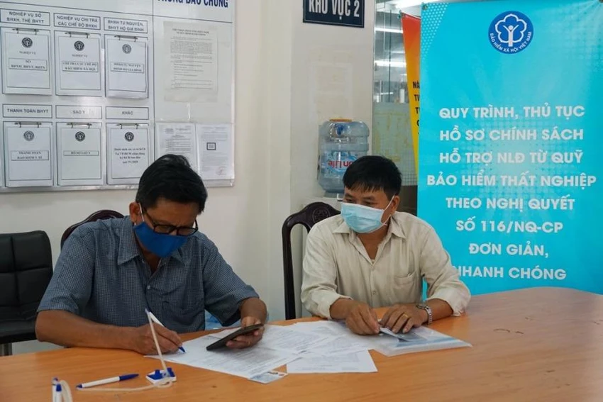 Người dân nhận tiền hỗ trợ từ quỹ BHTN. Ảnh: V.LONG
