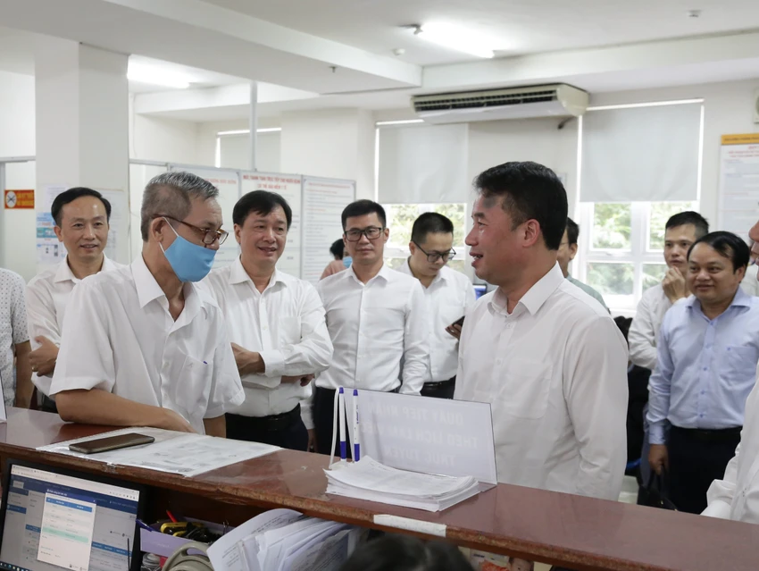 Tổng Giám đốc BHXH Việt Nam Nguyễn Thế Mạnh (bên phải) đang kiểm tra công tác ứng dụng công nghệ trong giải quyết thủ tục hành chính của ngành.