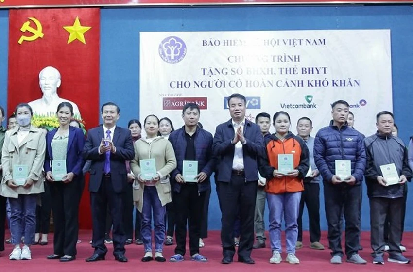 Tổng Giám đốc BHXH Việt Nam Nguyễn Thế Mạnh trao tặng thẻ BHYT và sổ BHXH cho người nghèo.