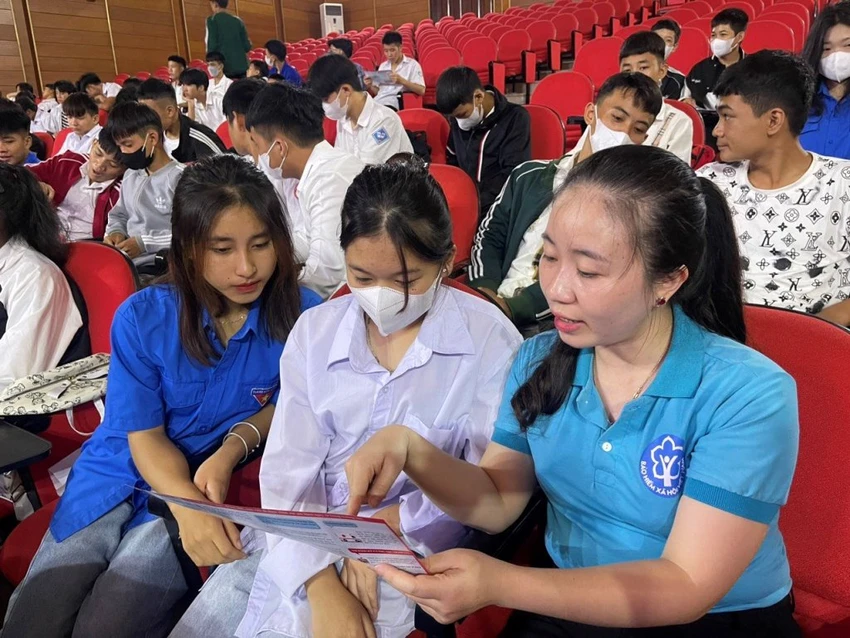 Nhân viên BHXH tuyên truyền chính sách BHYT cho học sinh, sinh viên.