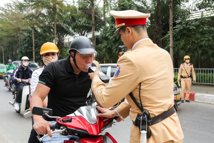 Lực lượng công an kiểm tra nồng độ cồn đối với người điều kiển xe máy. Ảnh: PHI HÙNG