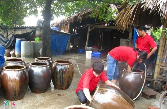 CBNV một công ty tại Hà Nội chuẩn bị chum để hạ thổ rượu cẩm, tự tay làm đặc sản tri ân đối tác và tứ thân phụ mẫu trong dịp lễ, Tết. Ảnh: Diệp Sa. Doanh nghiệp thưởng Tết bằng gà tiến vua, giò ngựa bạch