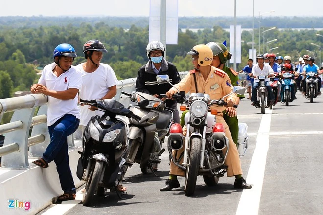 Cảnh sát giao thông liên tục tuần tra để nhắc nhở người dân không được dừng đỗ trên cầu. Vì là ngày đầu tiên nên cảnh sát chỉ nhắc nhở không xử phạt. Con đưa di ảnh ba mẹ ngắm cầu Mỹ Lợi ngày thông xe