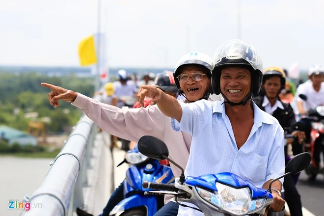 Anh Phạm Văn Mộng người Bình Đông, thị xã Gò Công chở bác Nguyễn Văn C qua thăm cầu. Sống ở đây 78 năm, bác C cho biết, rất háo hức chờ đợi ngày này. Con đưa di ảnh ba mẹ ngắm cầu Mỹ Lợi ngày thông xe