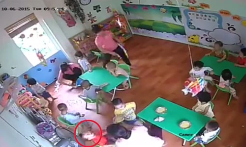 Cháu bé mặc áo đỏ bị cô giáo ôm đầu lắc mạnh, tát vào mặt khi cho ăn